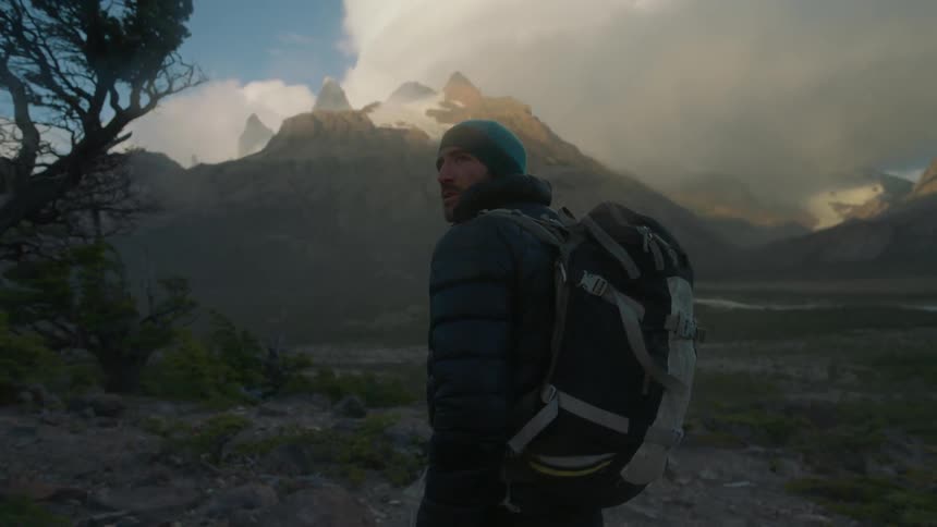 Man wearing a backpack hikes through the mountains