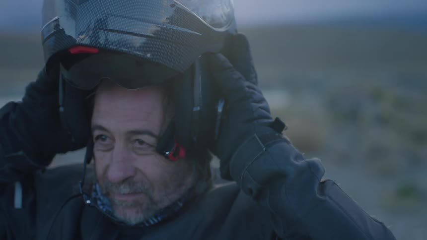 Man puts on a motorcycle helmet