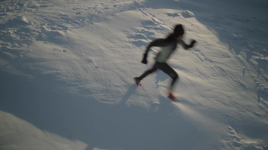 Woman jogs across snowy plains