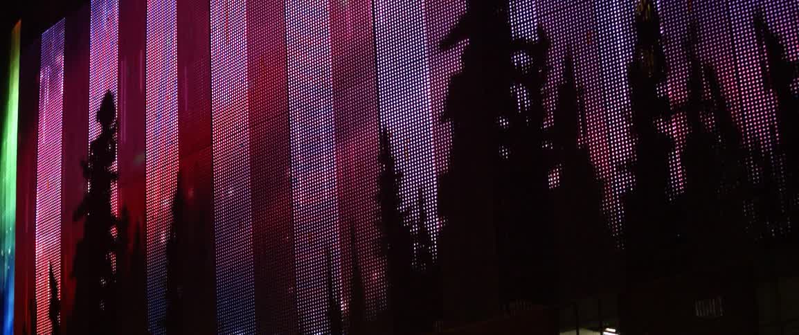 Large red and white vertical panels start to glow in front of some trees