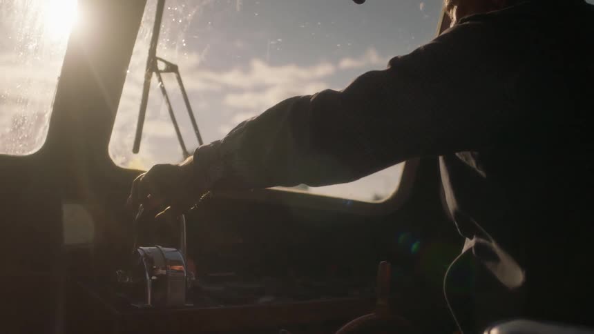 Man in a boat holds on to a lever