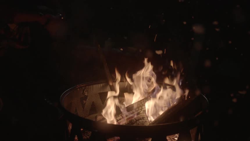 A campfire burns at night