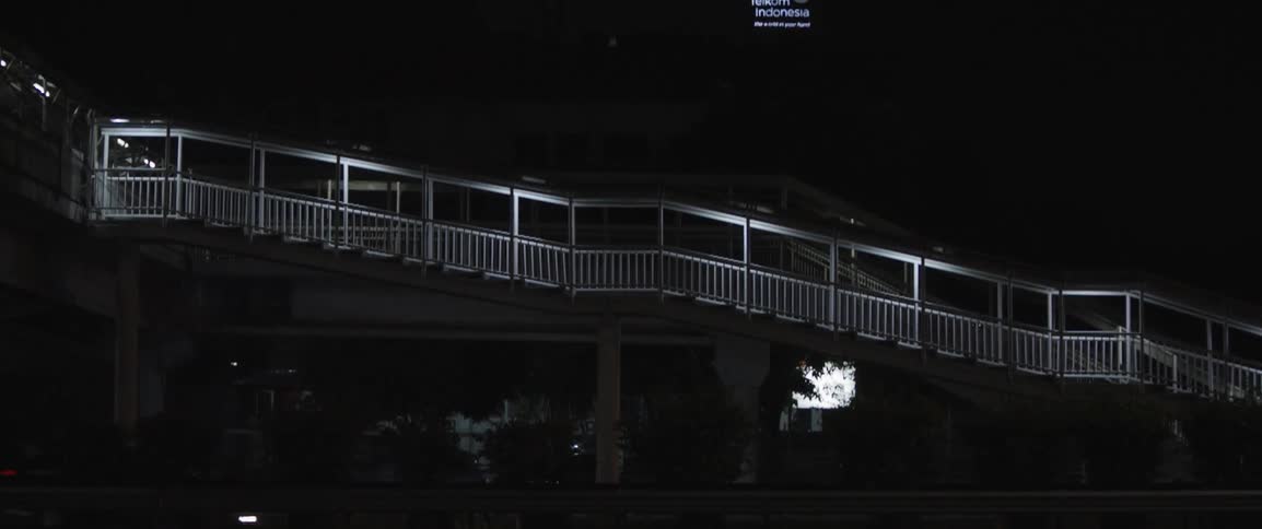 A city walkway is illuminated at night