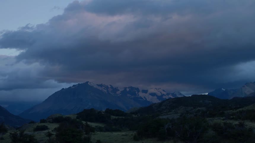 Clouds float over a mountain at sunset