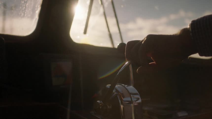 A person is steering a ship