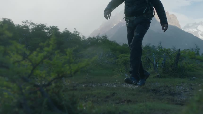 Man running over hilly grassy landscape