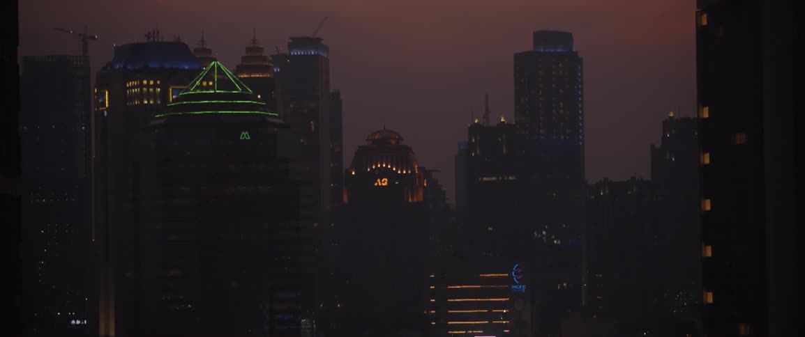 A city skyline is illuminated as dawn approaches