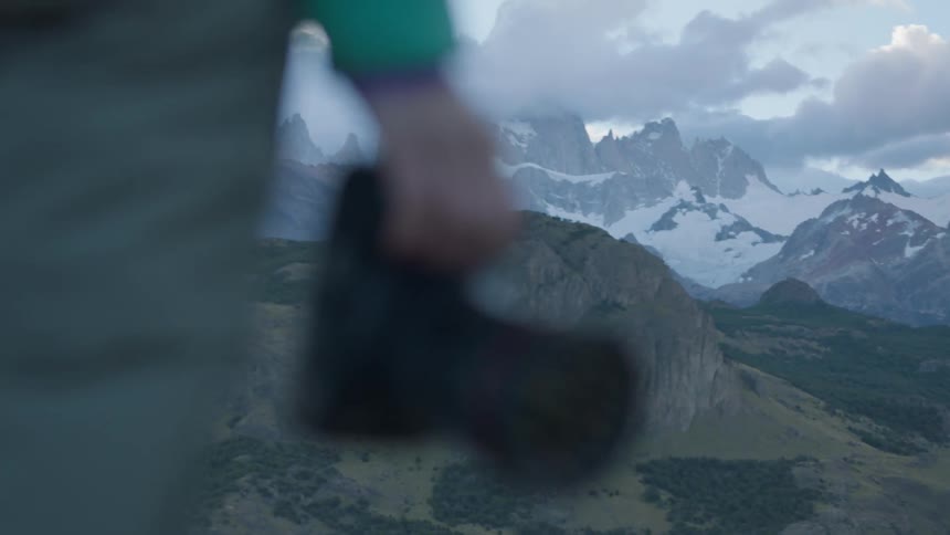 A photographer stands in snowy mountains