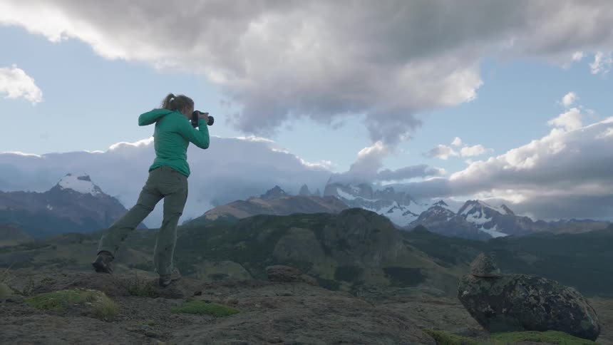 A woman is hiking on a windy mountain