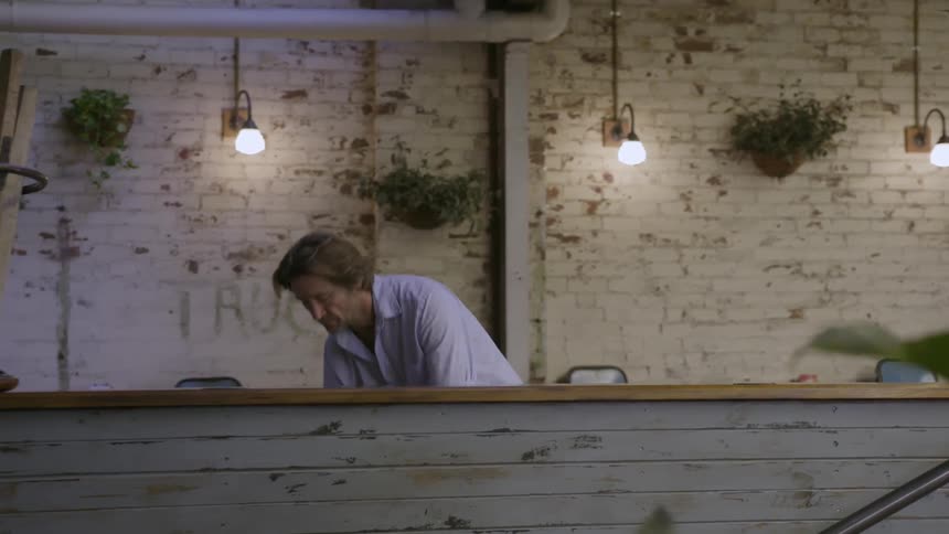 A man puts chairs down in a restaurant