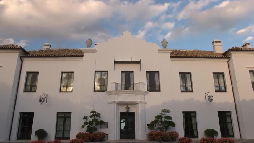 A large white building with a fountain in front