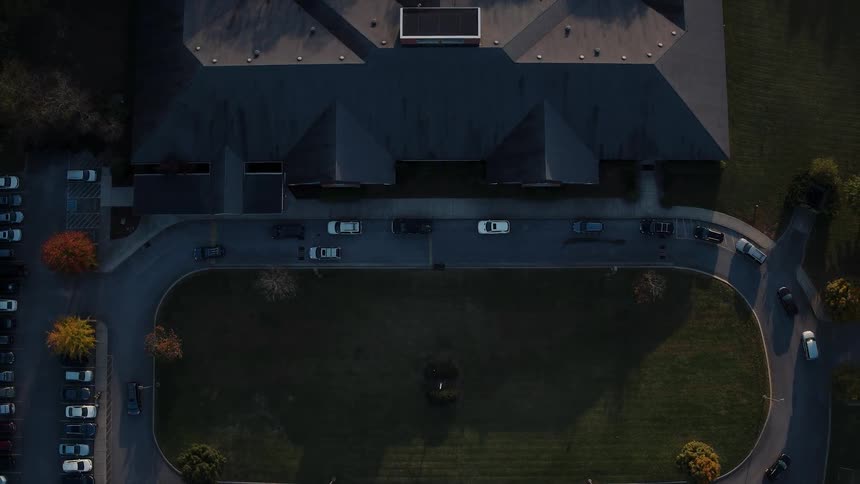 Cars drive on a road in front of a building