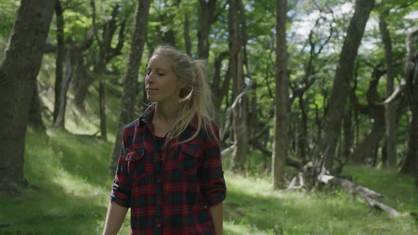 A woman walks through a forest