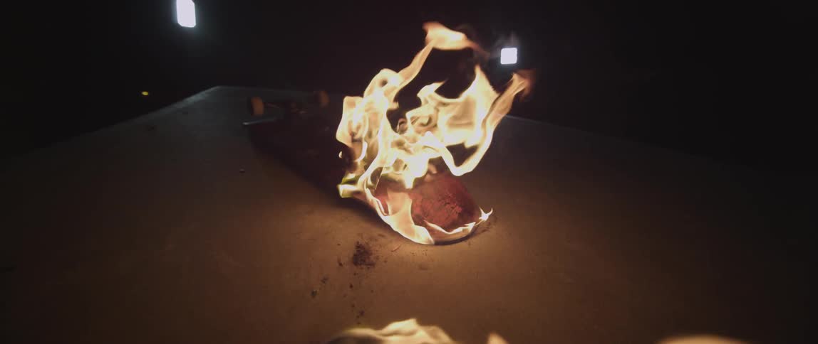 Skateboard lit on fire at night