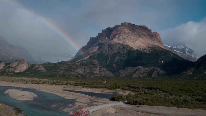 A rainbow arches over mountains