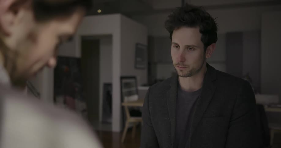Two men stand in a dining room talking