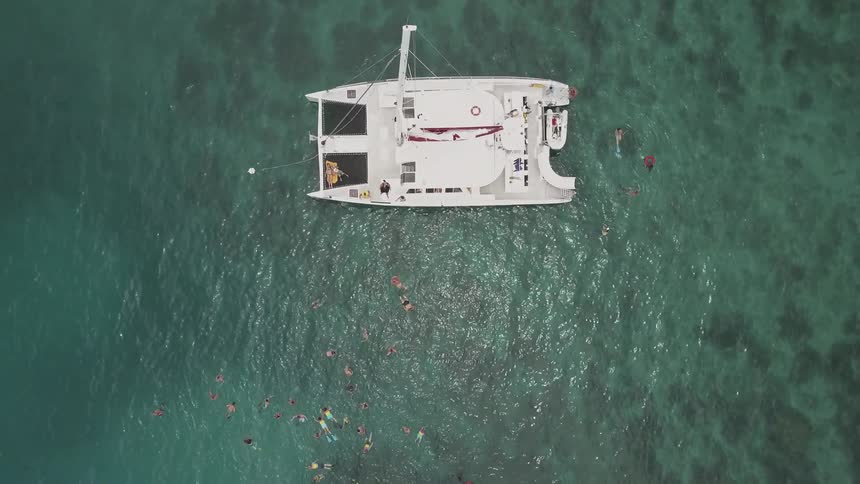 The boat is in the water with it's sail down