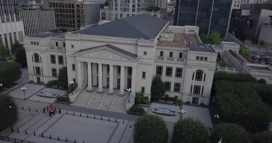 A large building sits before taller ones behind it