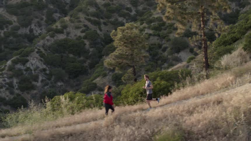 A man is jogging on a hiking trail