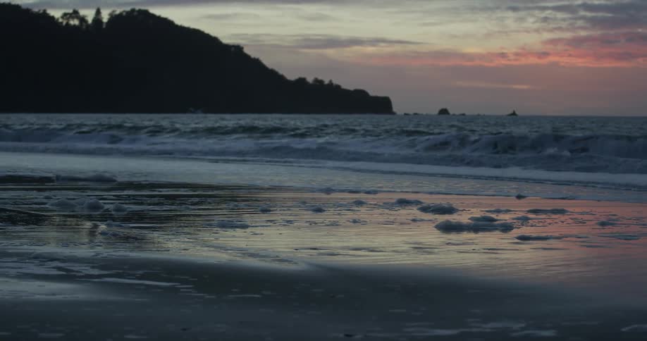 Ocean waves washing to shore at sunset