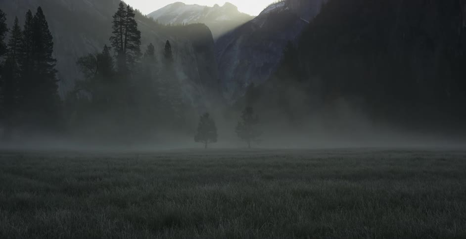 The field before the mountain is covered with fog