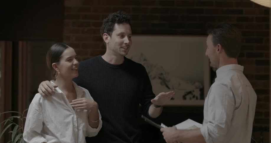A couple talk to a man with a folder