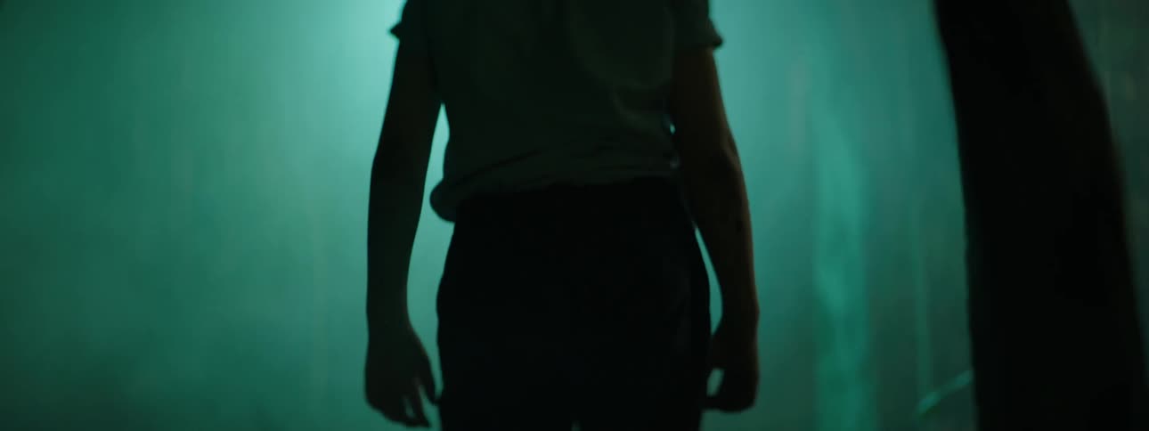A boy is searching for something in the woods at night