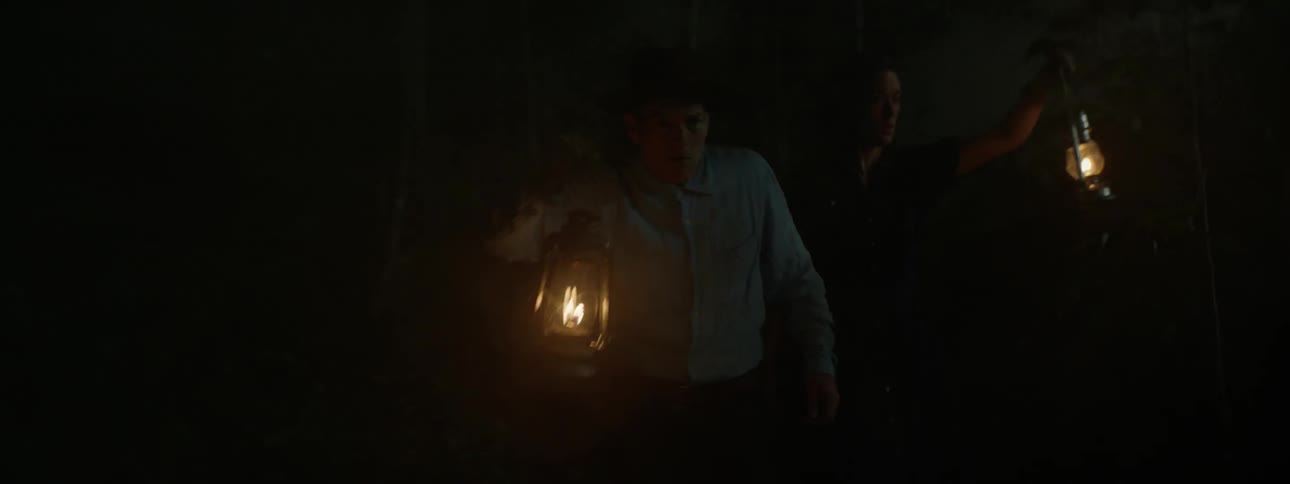 Two people holding lanterns at night