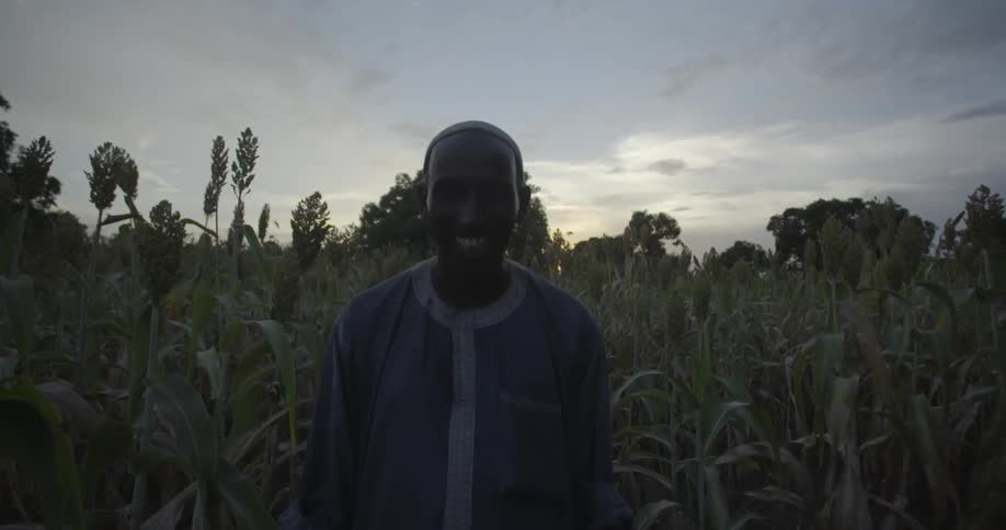 Man standing and smiling in a corn field
