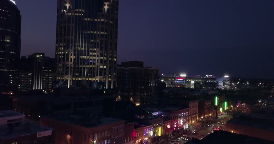 Cars drive on a city street at night