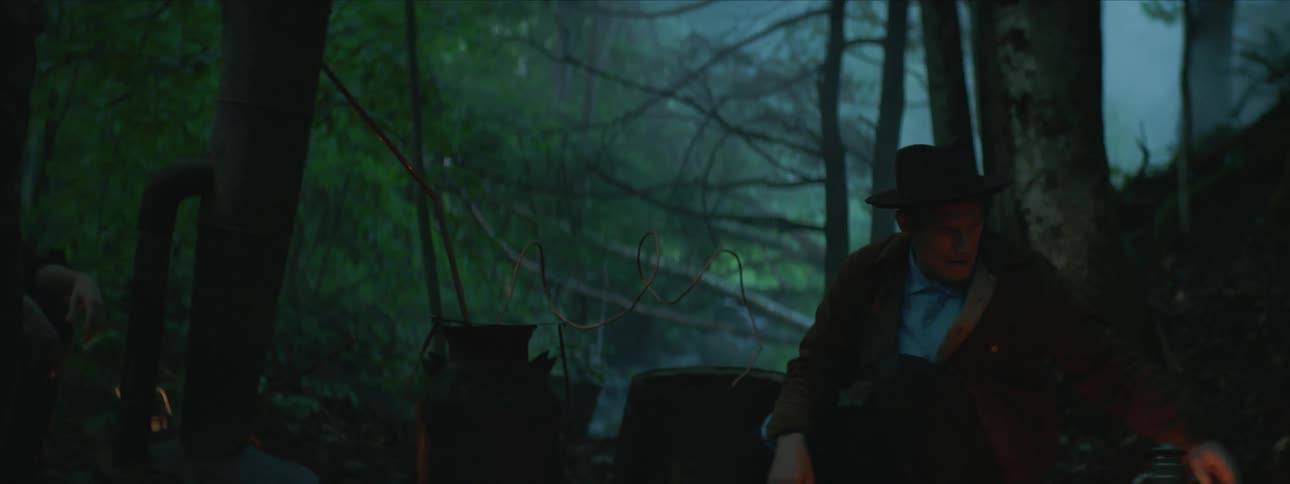 A man is sitting by a tree talking