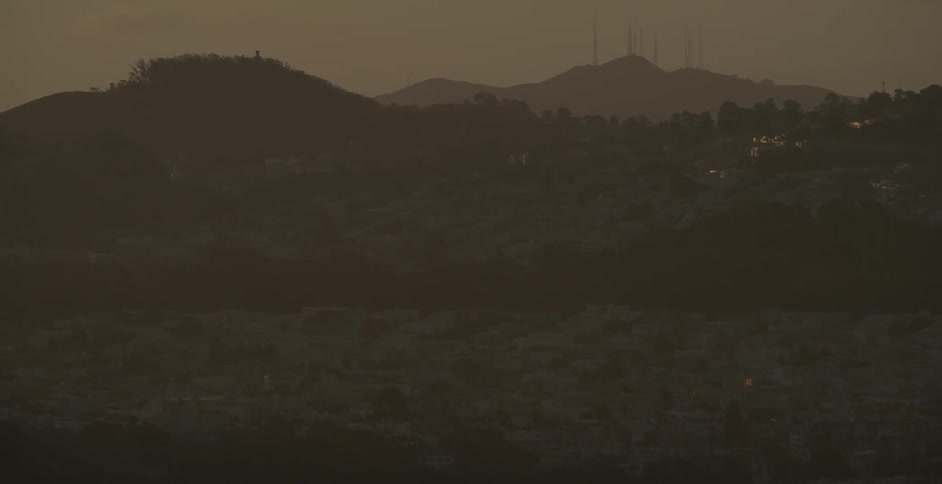 The hills ahead are covered with fog at dawn