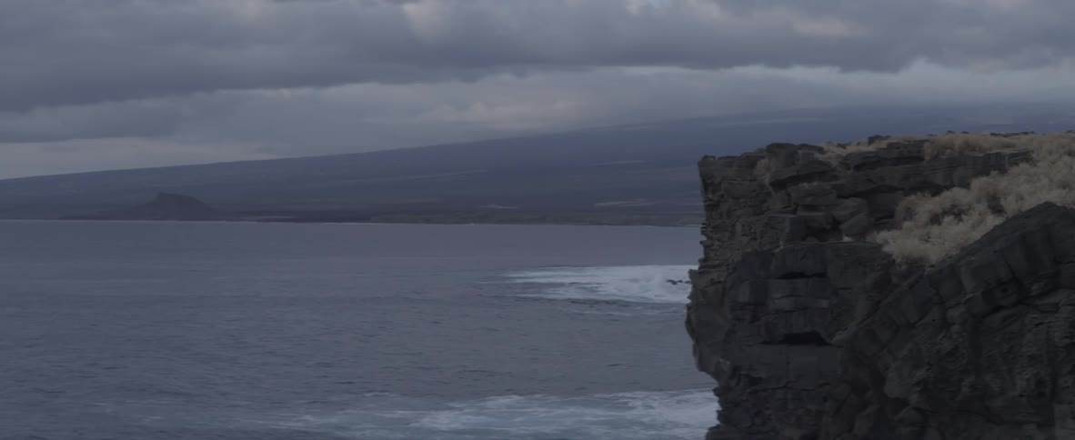 Cliff overlooking a body of water on a cloudy day