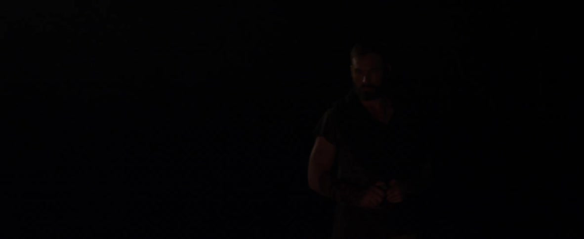 A man stands outside in the dark