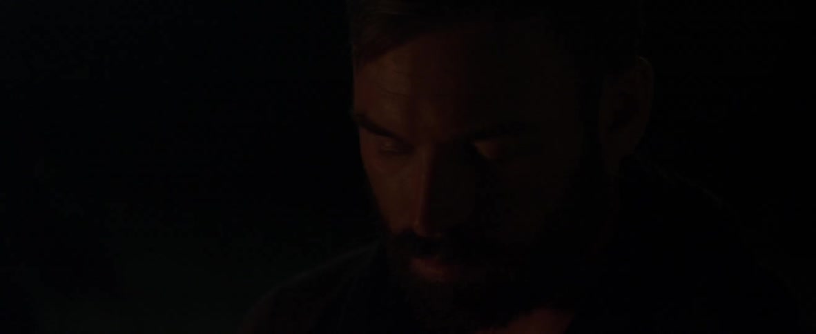 A man is looking down at night