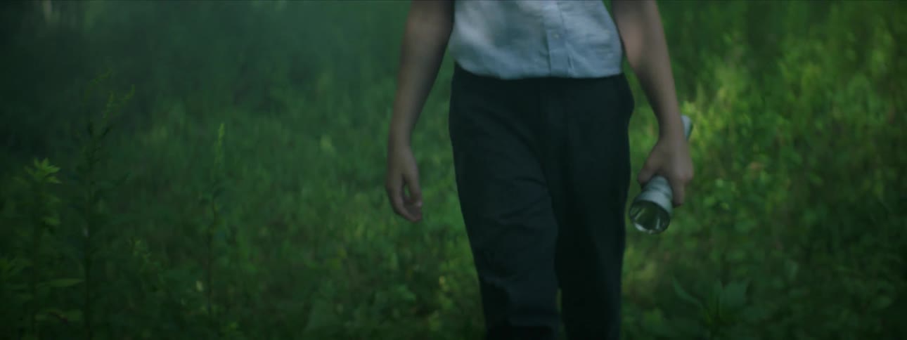 Someone is walking outdoors holding a flashlight
