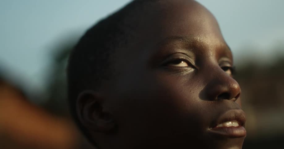 A boy blinks while standing outside