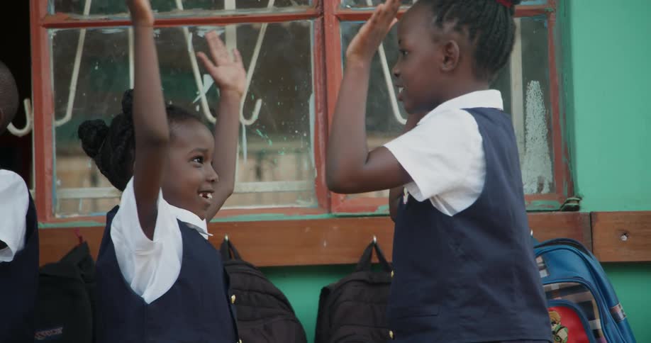 Two young students high five each other