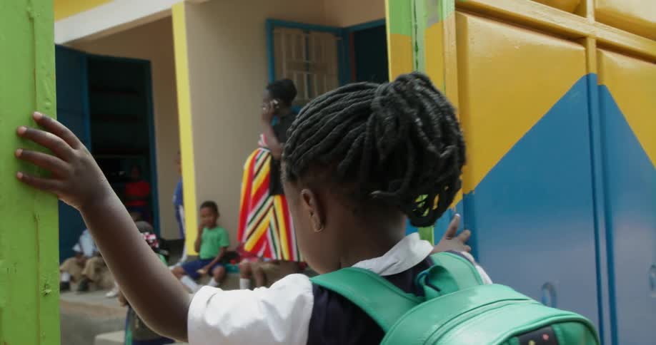 A student with a backpack enters a school yard