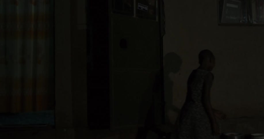 A boy walks inside a dark building