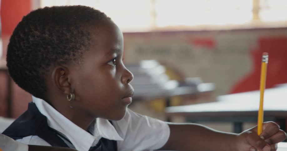 A child is writing in the book with a pencil