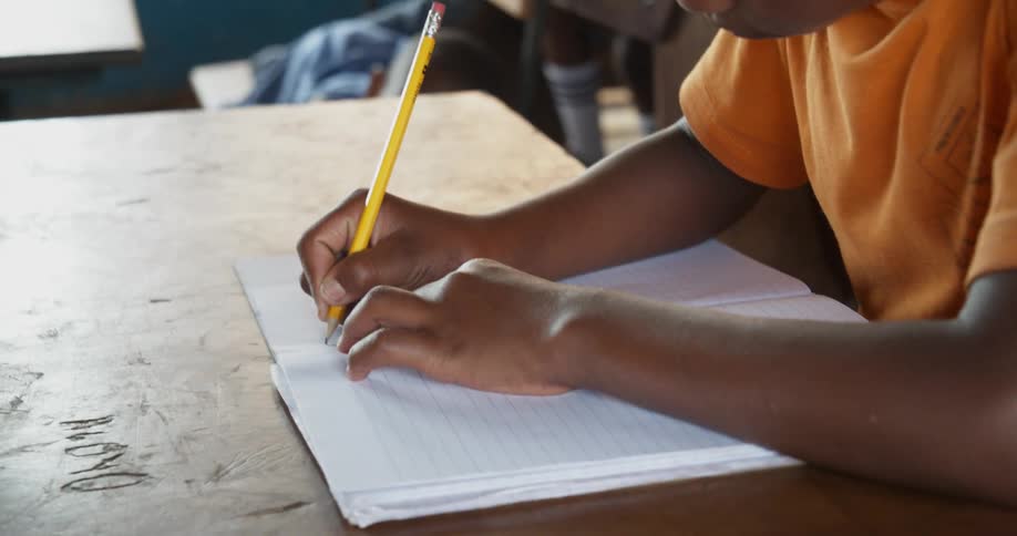 A boy takes notes in class