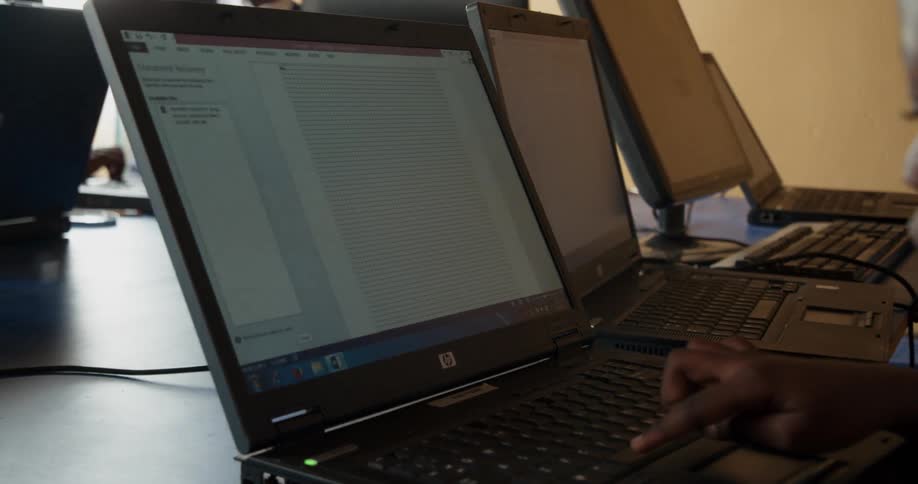A young girl is learning how to use a computer