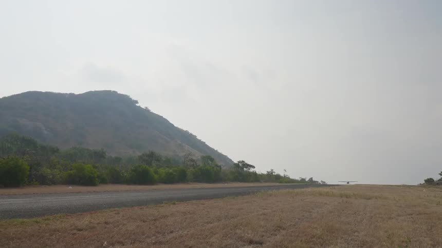 A stretch of road near a tall hill