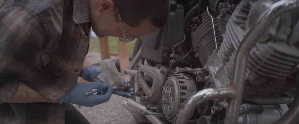 A man is working on his motorcycle