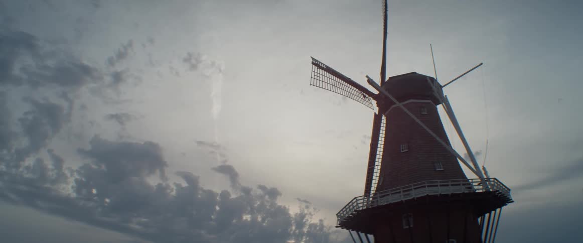 A windmill is shown at sunset