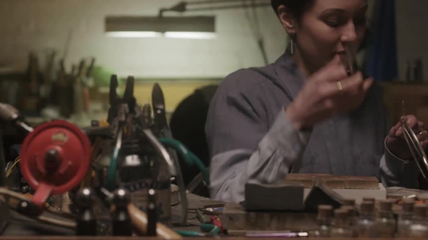 A woman grabs a pair of pliers to adjust a metal hoop