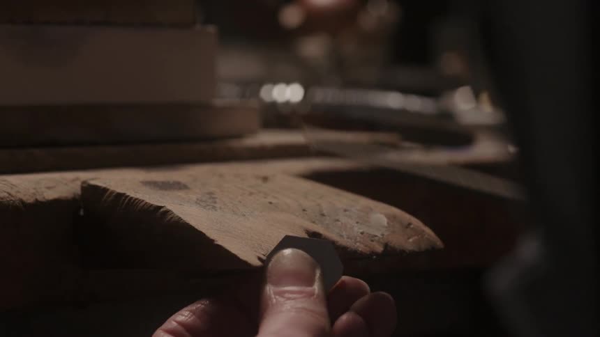 A person is shaving wood in a shop