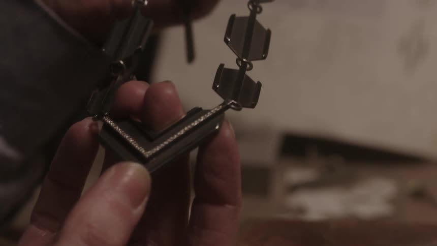A person is examining a necklace