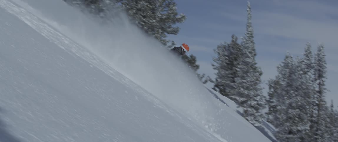 A man is skiing down a deep slope